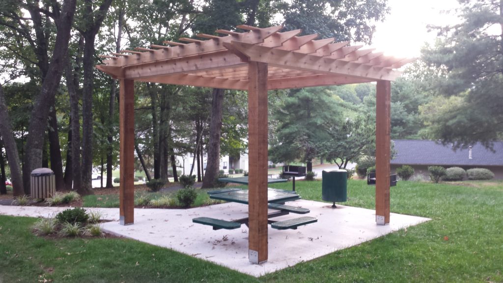 outdoor grilling area with pergola shelter, site furnishings, outdoor tables, benches